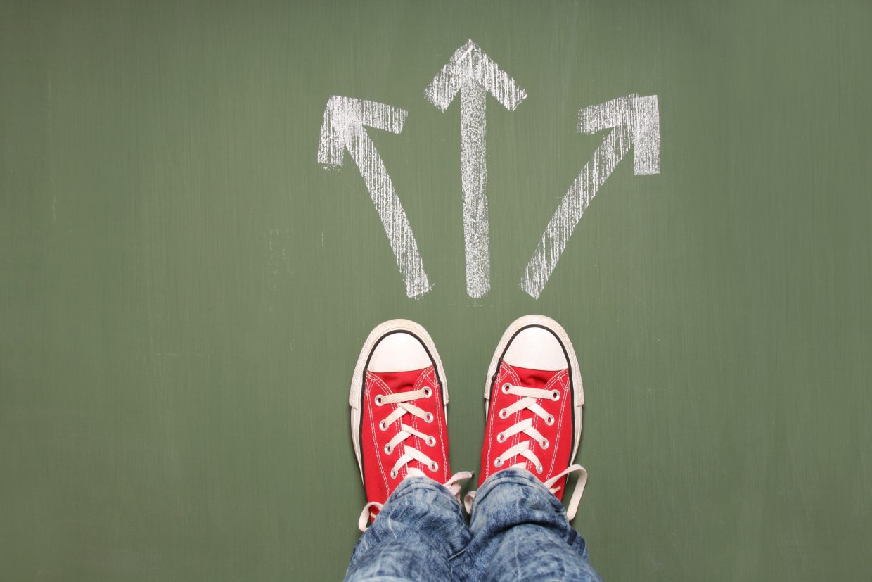 A person standing in front of three arrows showing different waysSome
